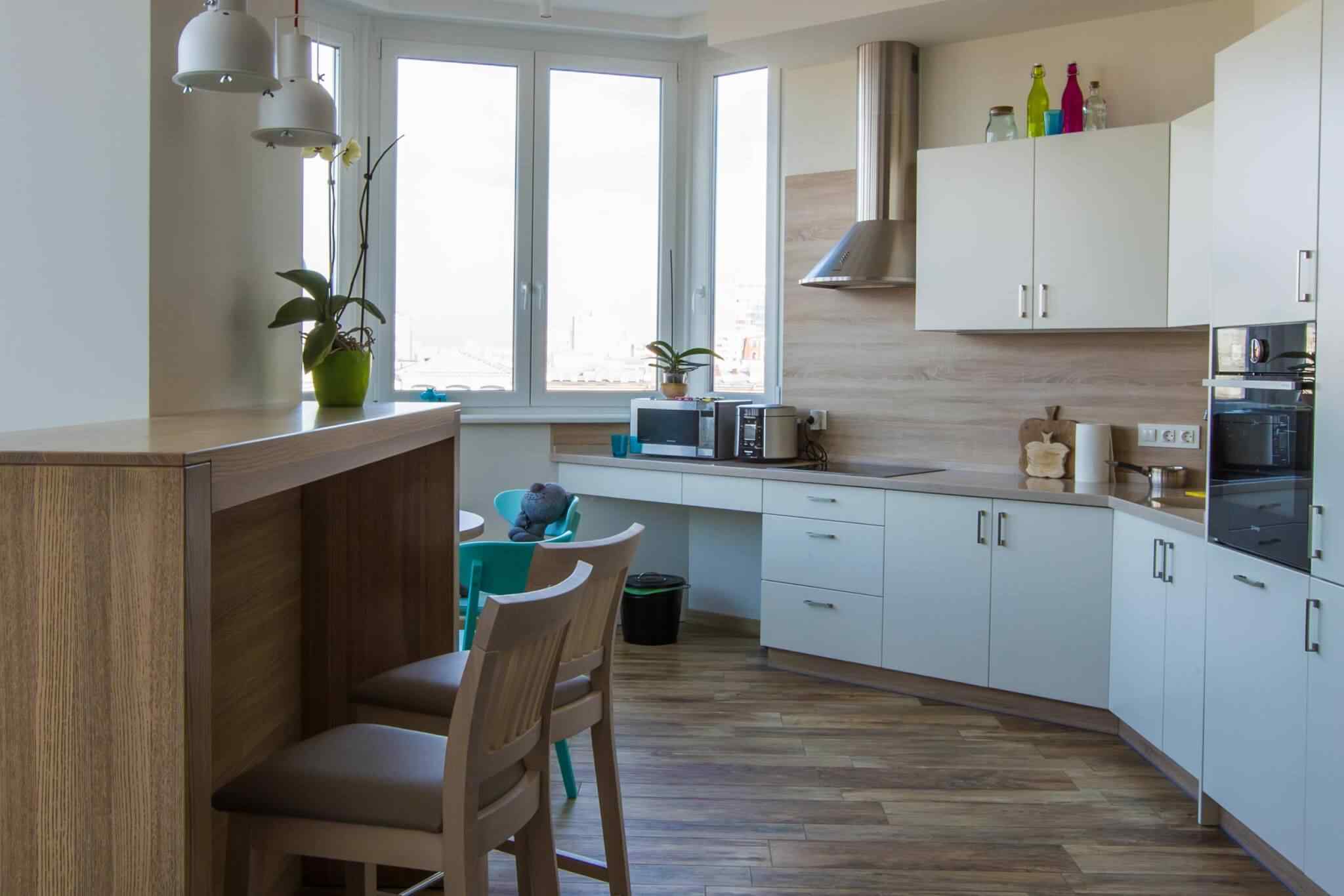 A kitchen with white cabinets and wooden floors.