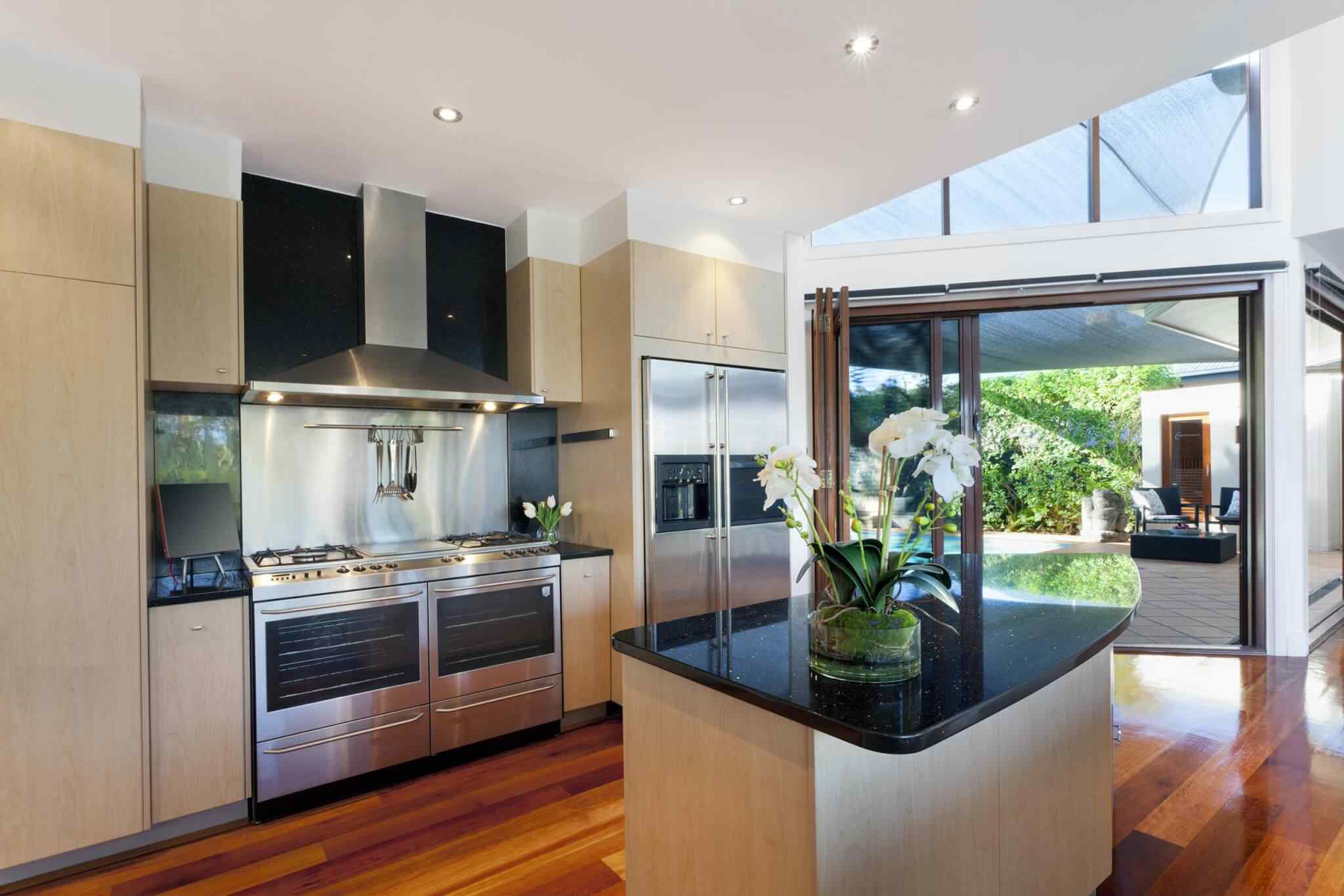 A kitchen with stainless steel appliances and black granite counter tops.