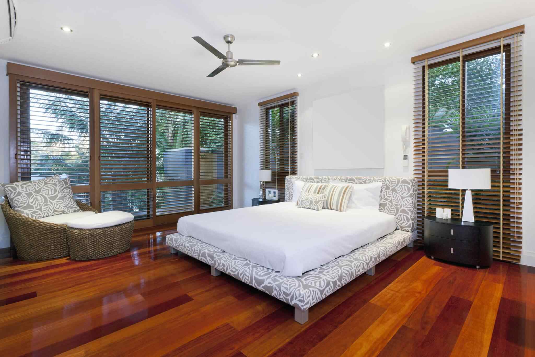 A bedroom with hardwood floors and white walls.