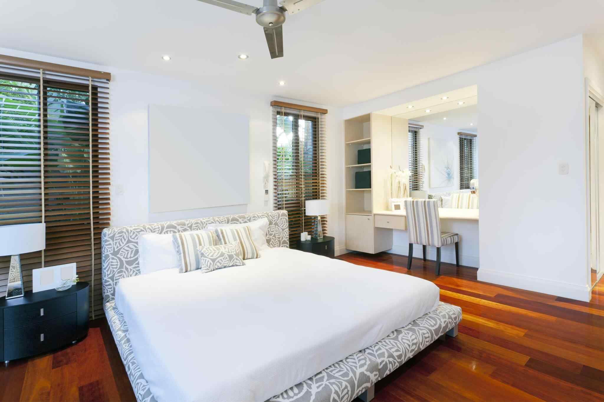 A bedroom with a large bed and wooden floors