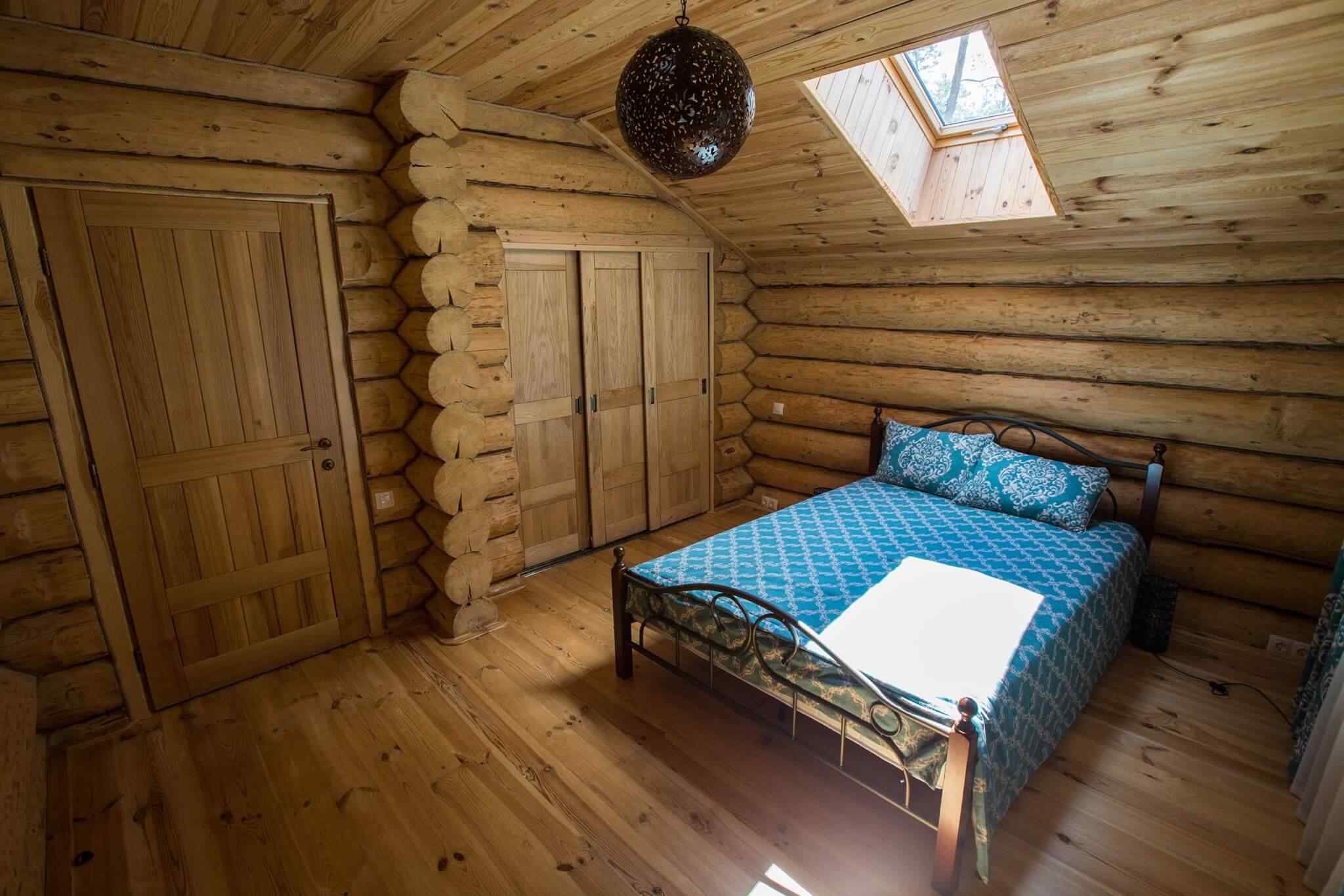 A bedroom with wood floors and a bed in it.