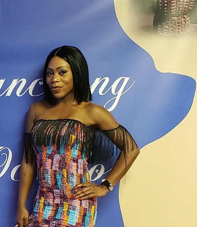 A woman in a colorful dress posing for the camera.