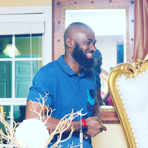 A man with a beard standing in front of a mirror.