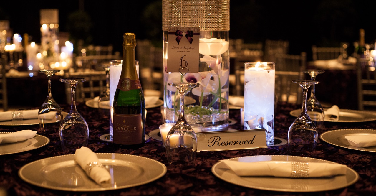 A table set with plates, candles and wine.