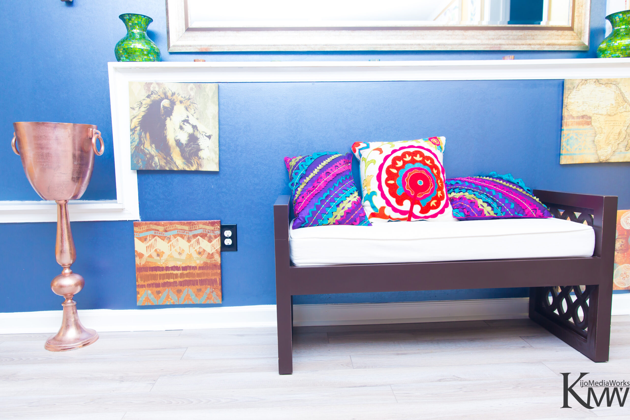 A colorful pillow on the back of a bench.