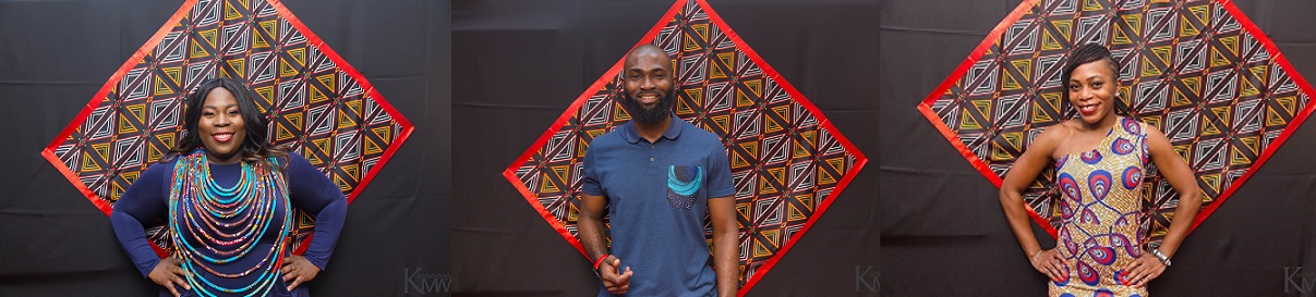 A man standing in front of a wall with an african print.